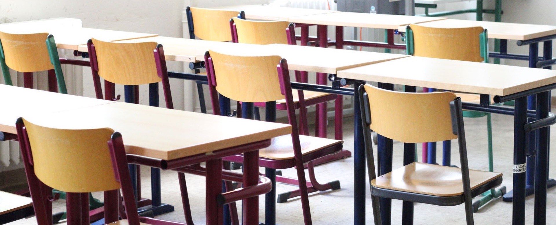 Wooden desks and chairs in an empty classroom